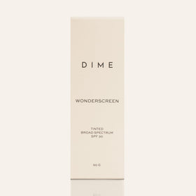 DIME tube next to a 50 g scale showing compact travel-friendly size