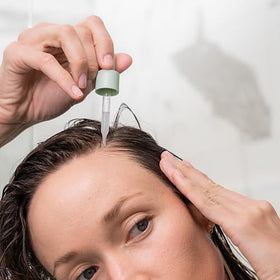 divi serum on bathroom shelf with towel, suggests easy daily routine integration