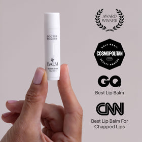 Doctor Rogers lip balm next to coin showing compact size and portability