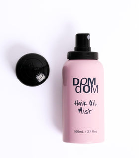 Dom Dom bottle beside avocado and olive to highlight nourishing ingredients