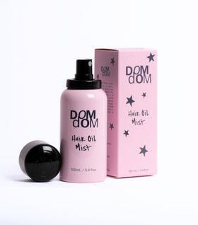 Dom Dom bottle spraying fine mist demonstrating even lightweight coverage