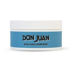 Model applying Don Juan pomade in beach setting for casual texture