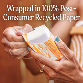 Dr. Bronner's citrus bar wrapped in recycled paper showing reduced waste benefit