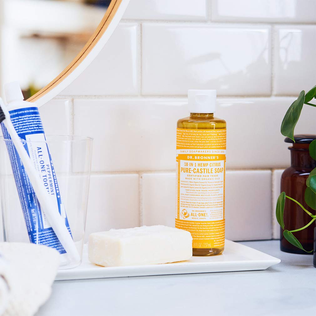Dr. Bronner's citrus bottle pouring into water demonstrating dilution for cleaning