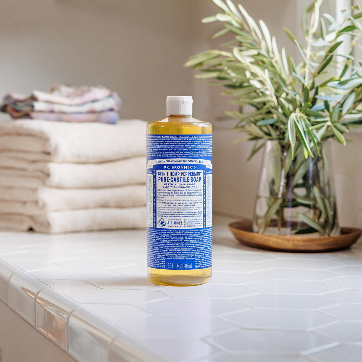 Dr. Bronner's bottle held in hand illustrating 25 oz scale and grip