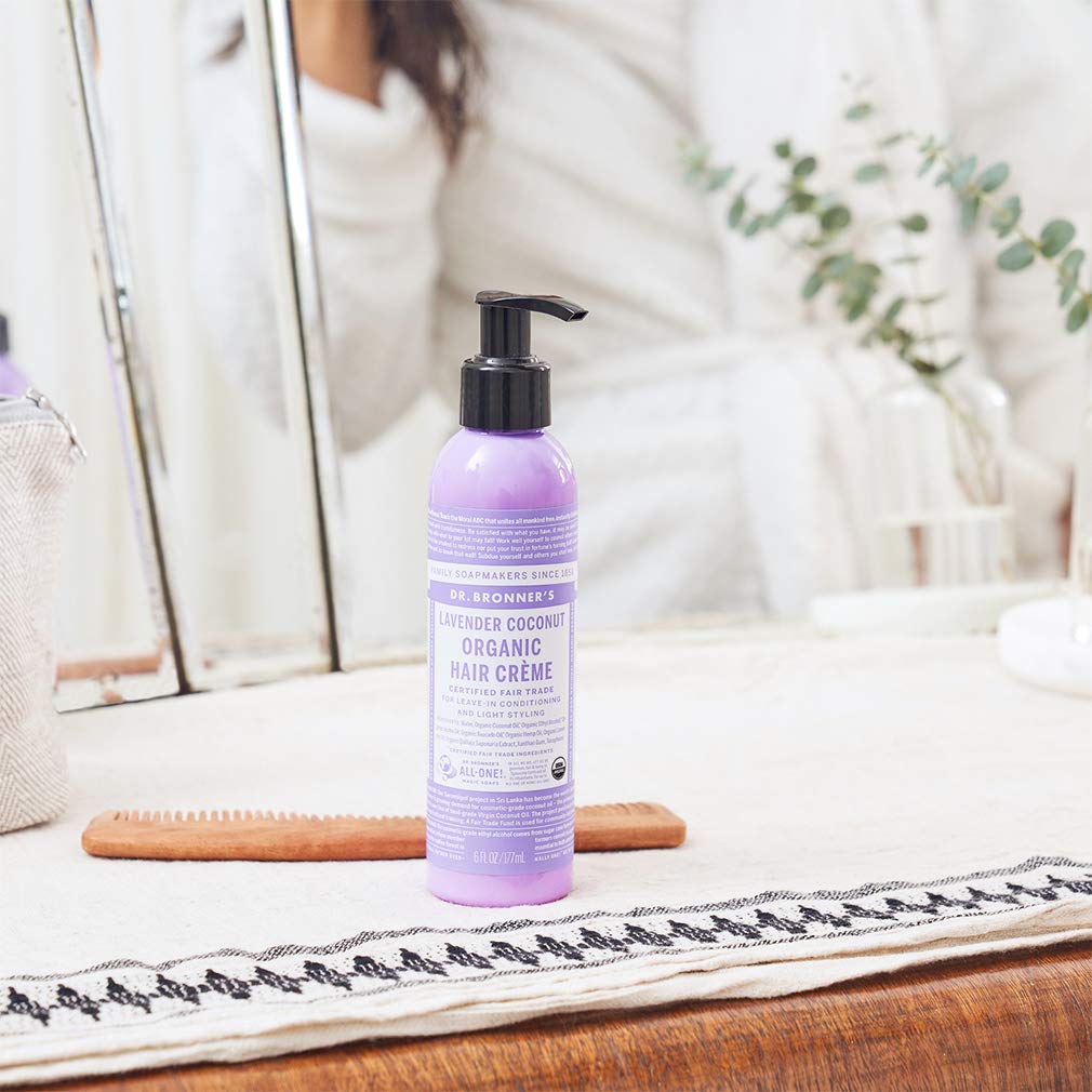 Dr. Bronner's hand applying creme to hair demonstrating easy distribution and light hold benefit