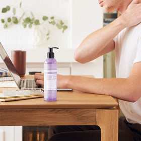 Hand holding Dr. Bronner's peppermint bottle showing cooling, refreshing feel