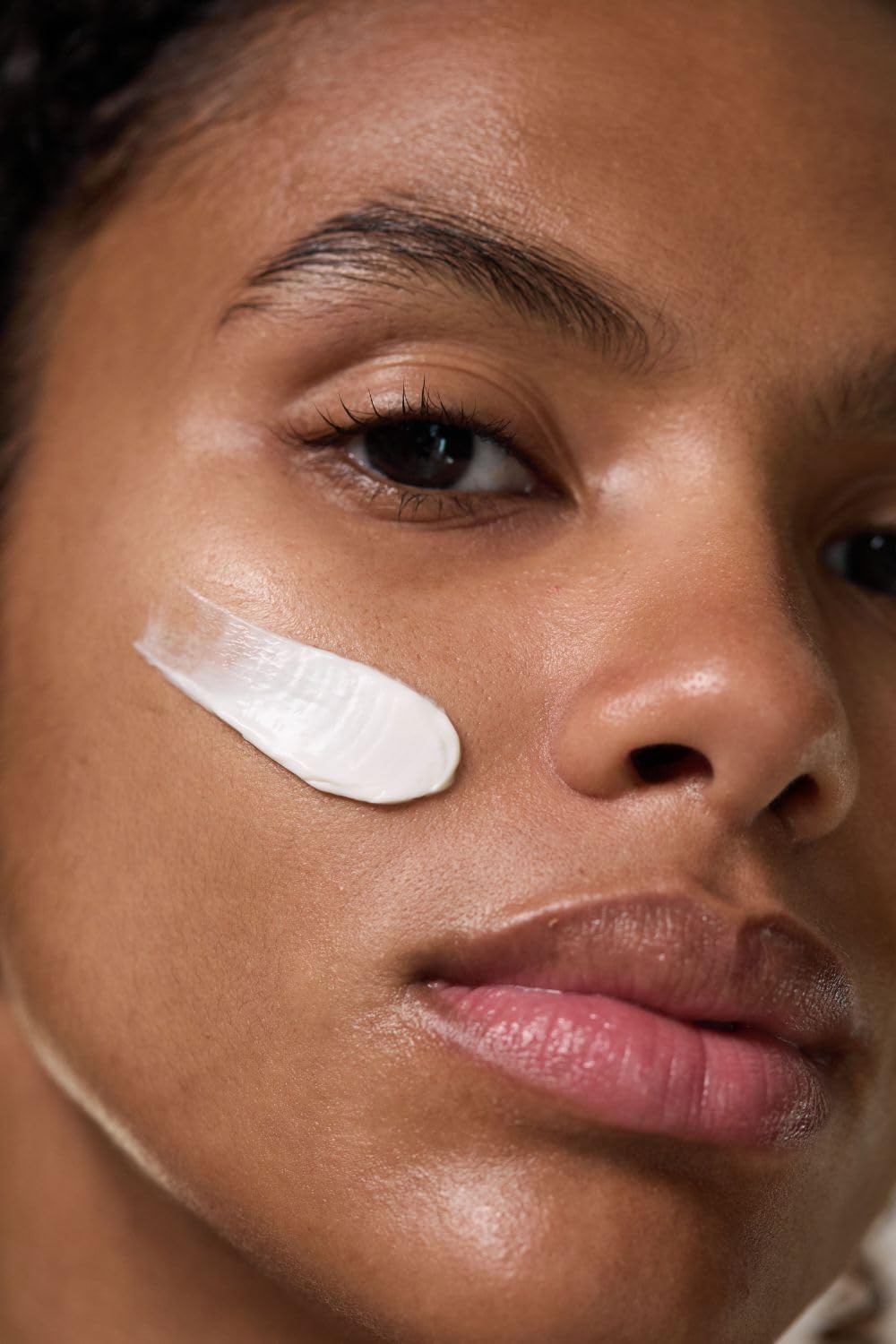 Dr. Hauschka mask being smoothed onto cheek demonstrating easy application and calming effect