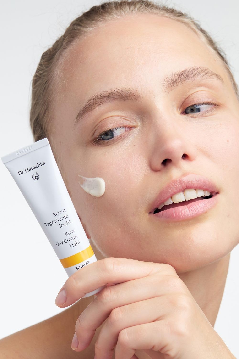 Dr. Hauschka 1 fl oz jar next to common items to show true size