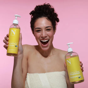 Dr. Natural held while washing a small dog showing mild pet-safe wash