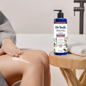 Dr Teal's bottle in hand demonstrating 18 fl oz size and portability