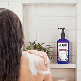 Dr Teal's body wash being poured on loofah to show buildable lather and easy application