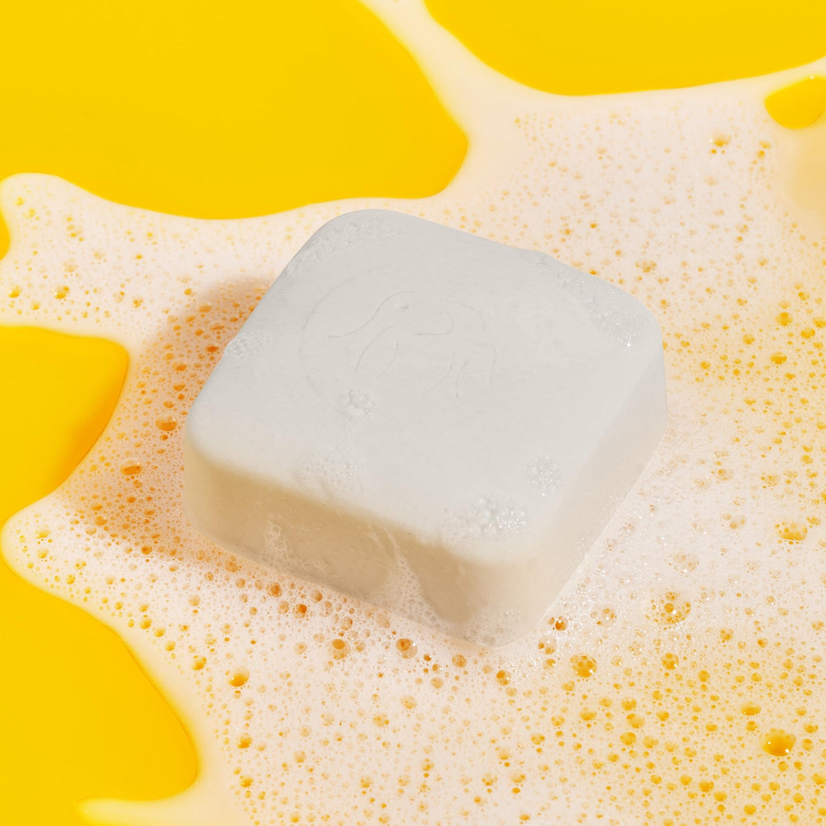 Drunk Elephant Pekee Bar lathered in hands demonstrating gentle foam