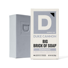 Duke Cannon bar staged by campfire evoking wood and leather scent benefit