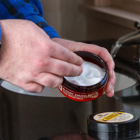 Duke Cannon balm being applied to knuckles for rapid repair benefit