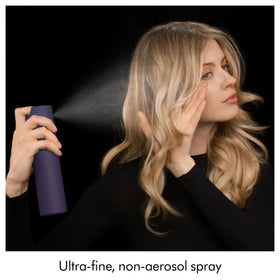 Applying Dyson Chitosan to curly hair to refresh and define natural bounce