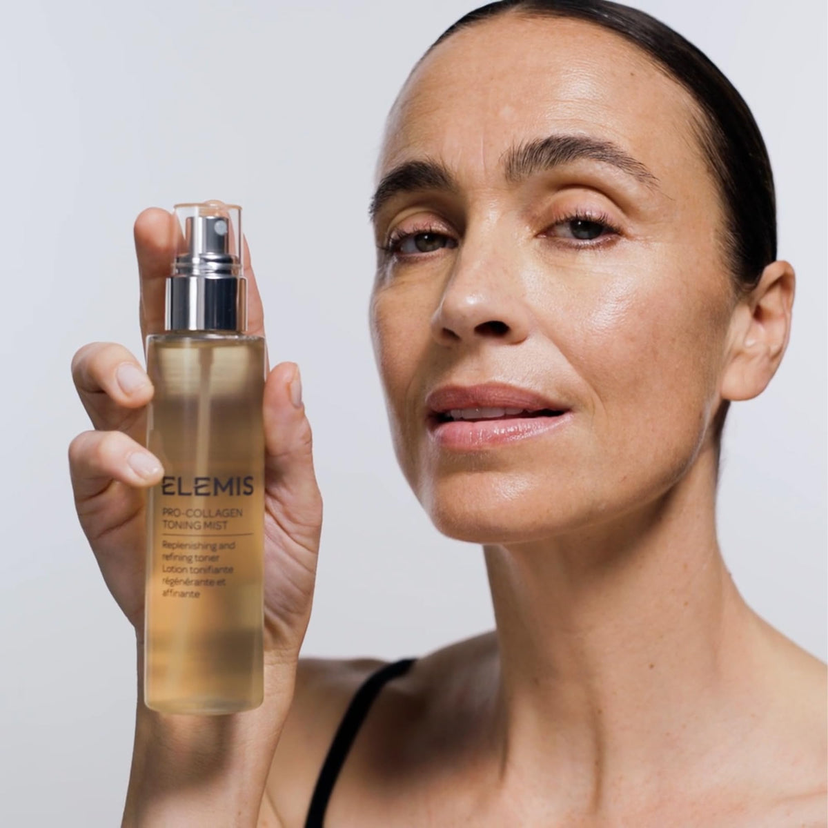 ELEMIS bottle next to hand showing 150ml scale and travel-friendly size