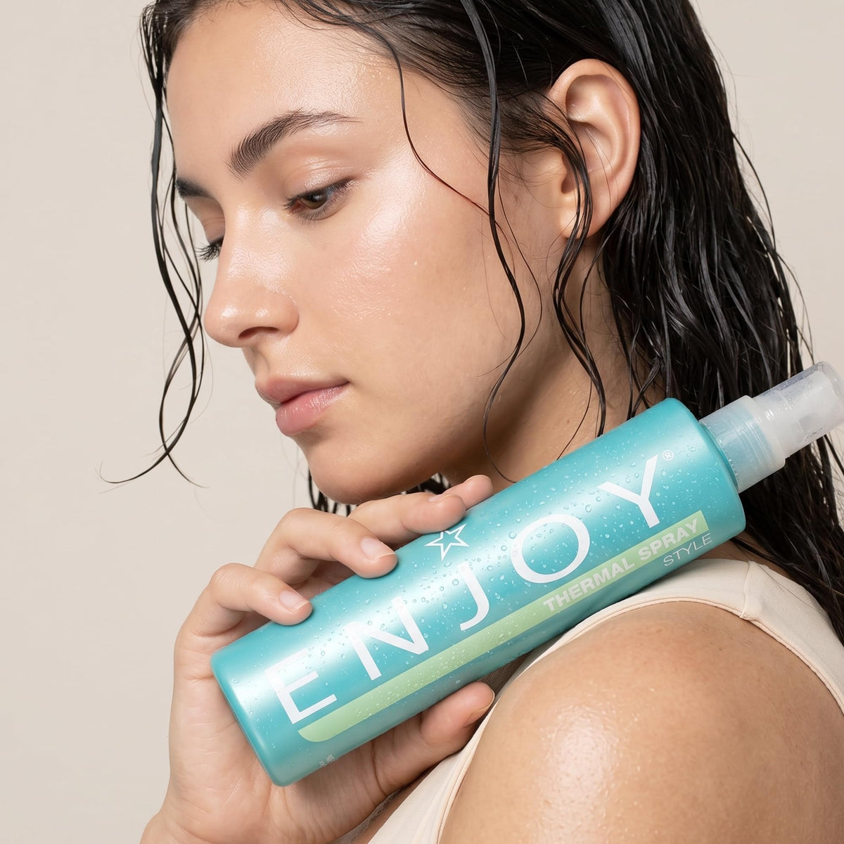 Enjoy thermal spray beside a hand for size comparison and portability