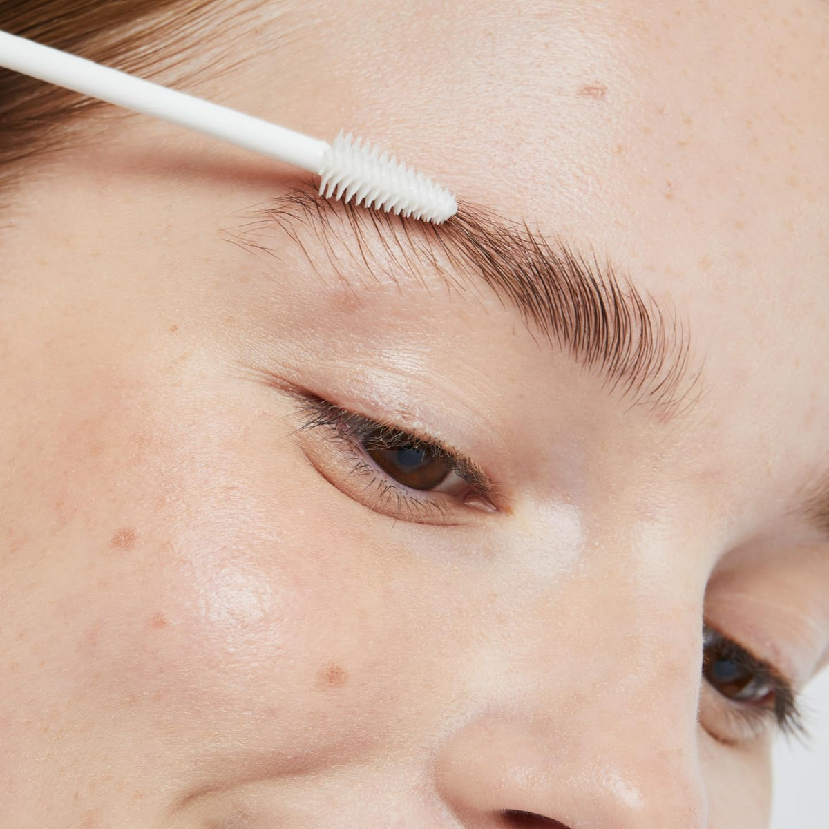 Ere Perez brow styling in use grooming brows into sleek, natural shape