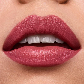 Estée Lauder lipstick next to ruler for size and scale indicating portable, everyday convenience