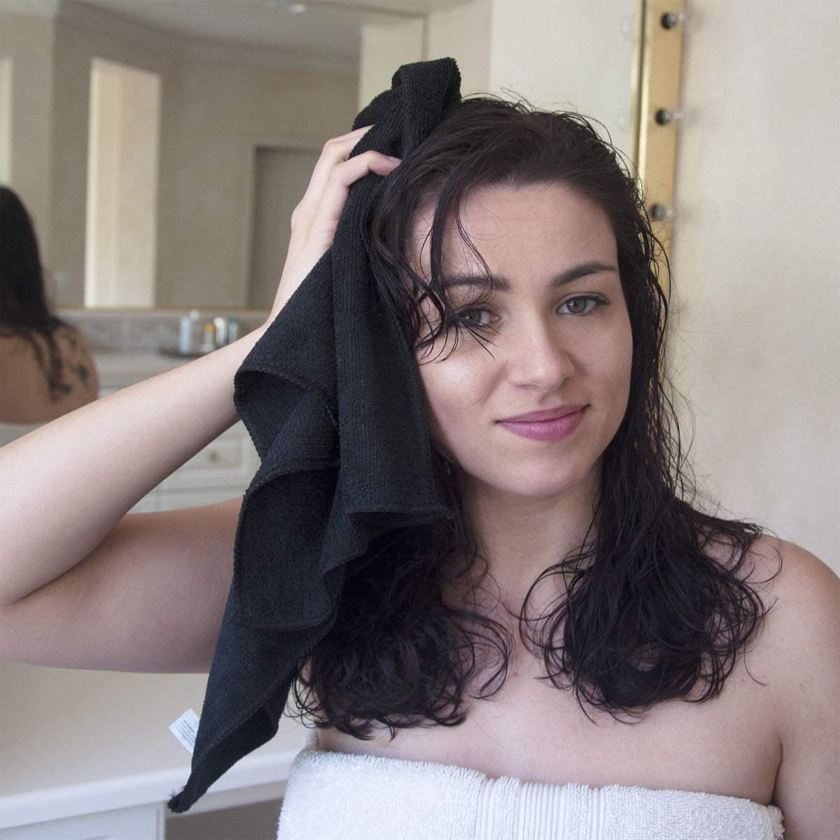 Eurow towel folded in hand showing 16x29 size and lightweight, easy-to-handle benefit