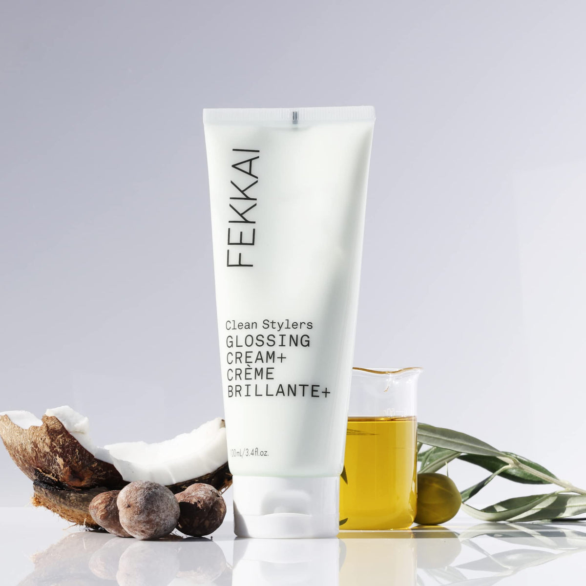 FEKKAI glossing cream next to a ruler showing 3.4 oz size for travel convenience