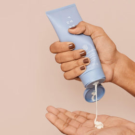 FENTY BEAUTY applying treatment to damp hair illustrating improved manageability benefit