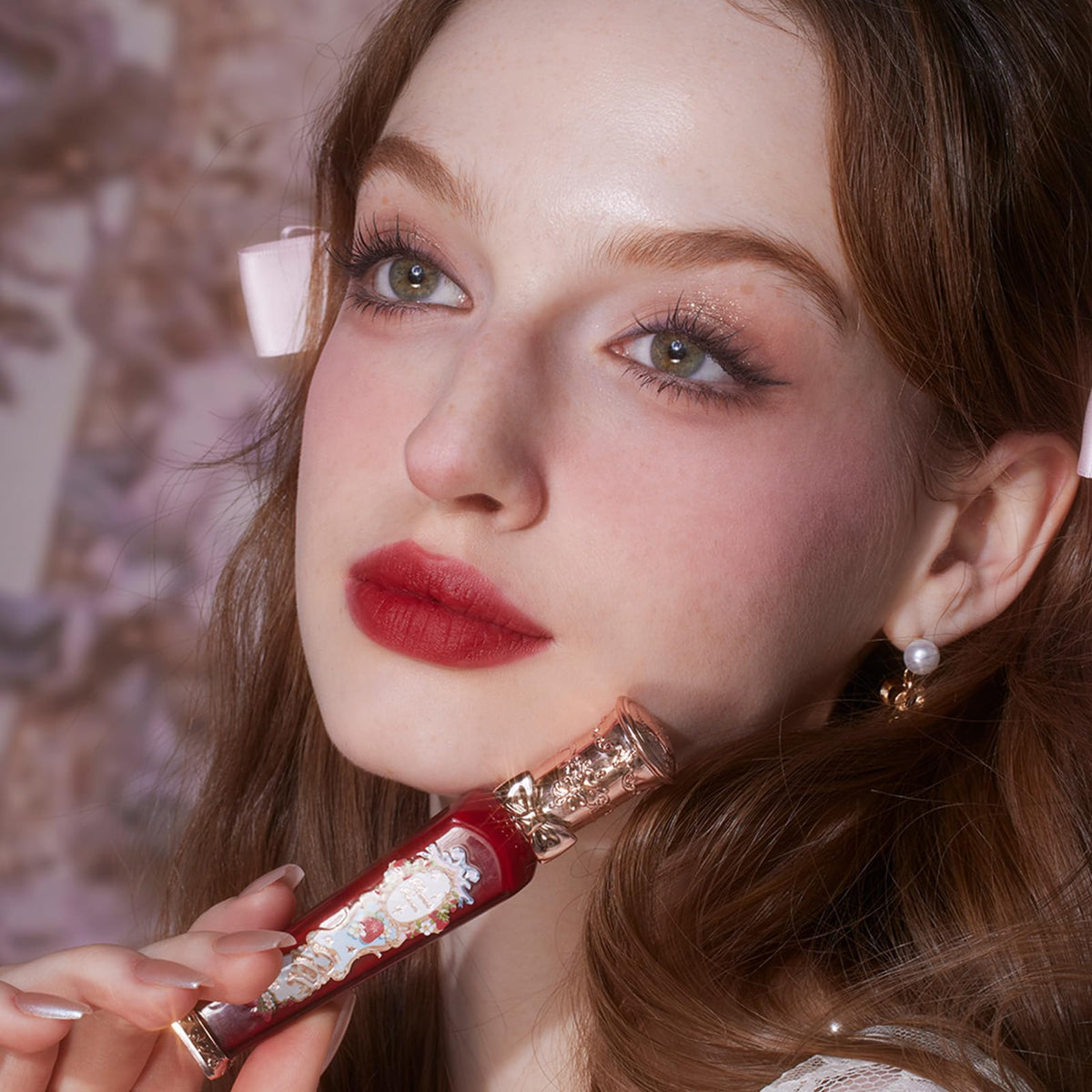 Flower Knows lip swatch on model demonstrating true warm brick-red shade