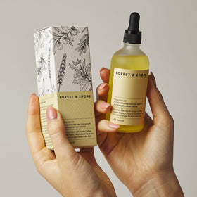Forest & Shore bottle in hand for scale and easy everyday use benefit