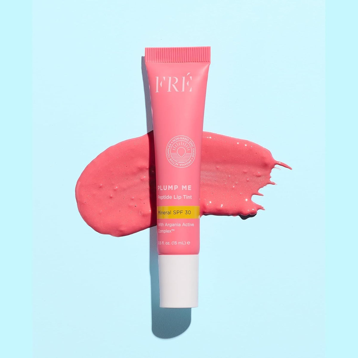 FRÉ lip tint held in hand showing compact 0.5 oz travel-friendly size