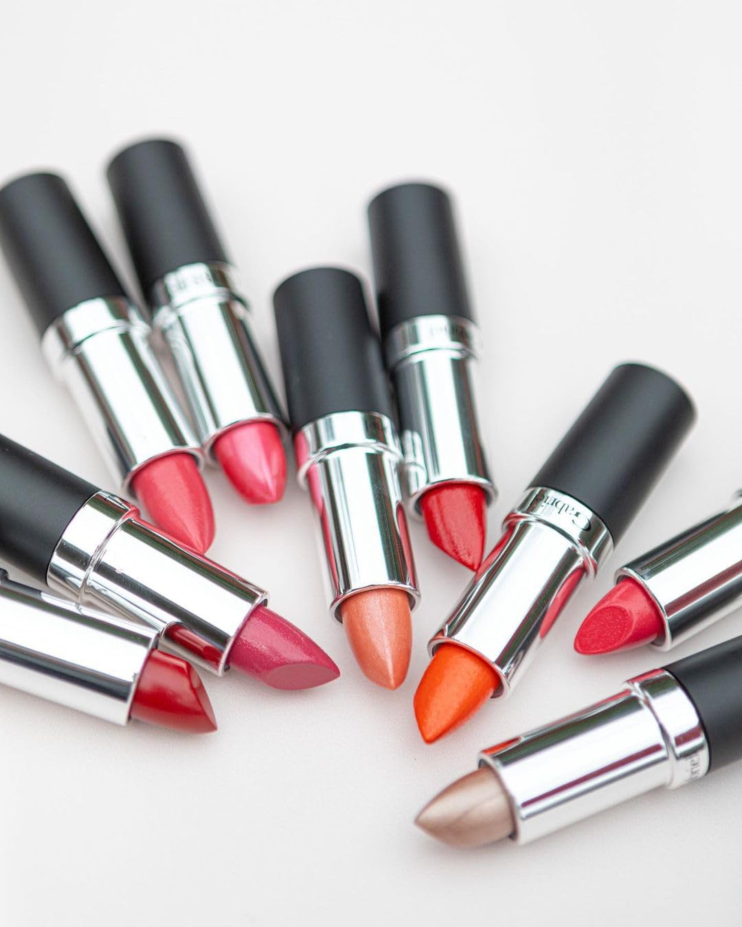 Gabriel Cosmetics lipstick next to coin for scale showing compact travel size