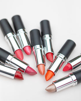 Gabriel Cosmetics lipstick next to coin for scale showing compact travel size
