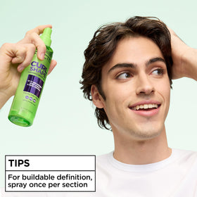 Garnier Fructis bottle held in hand showing 8.5 fl oz scale for portability