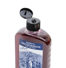 Close-up of Generic Barrys Tricopherous liquid texture on fingers, showing smooth application benefit
