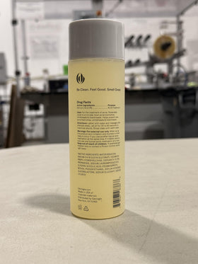 Geologie bottle beside a hand showing 8.4 fl oz scale and easy shower storage benefit