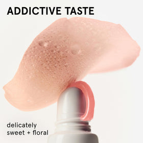 Glossier Balm Dotcom swiped on lips showing subtle pink tint and natural finish
