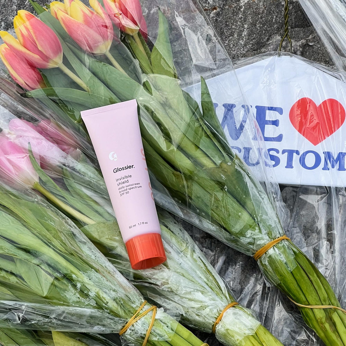 Glossier Invisible Shield tucked inside backpack for on-the-go reapplication