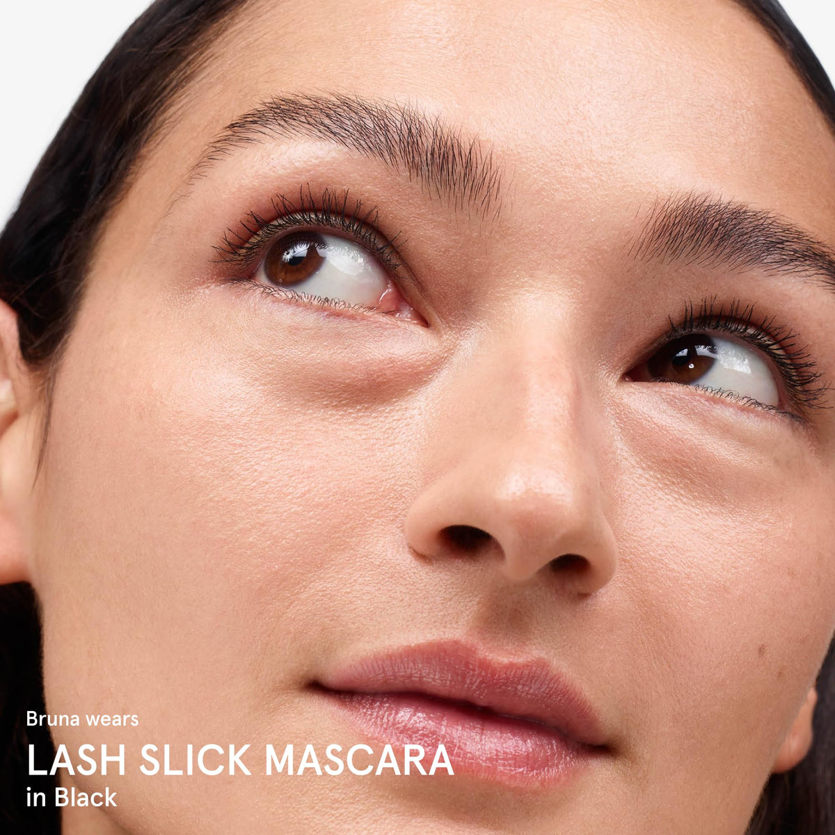Glossier Lash Slick in a toiletry bag lifestyle shot conveying everyday wearability and convenience