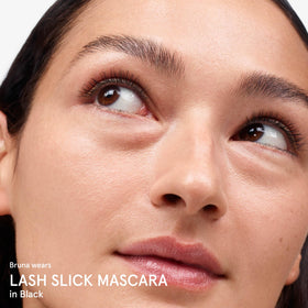 Glossier Lash Slick in a toiletry bag lifestyle shot conveying everyday wearability and convenience