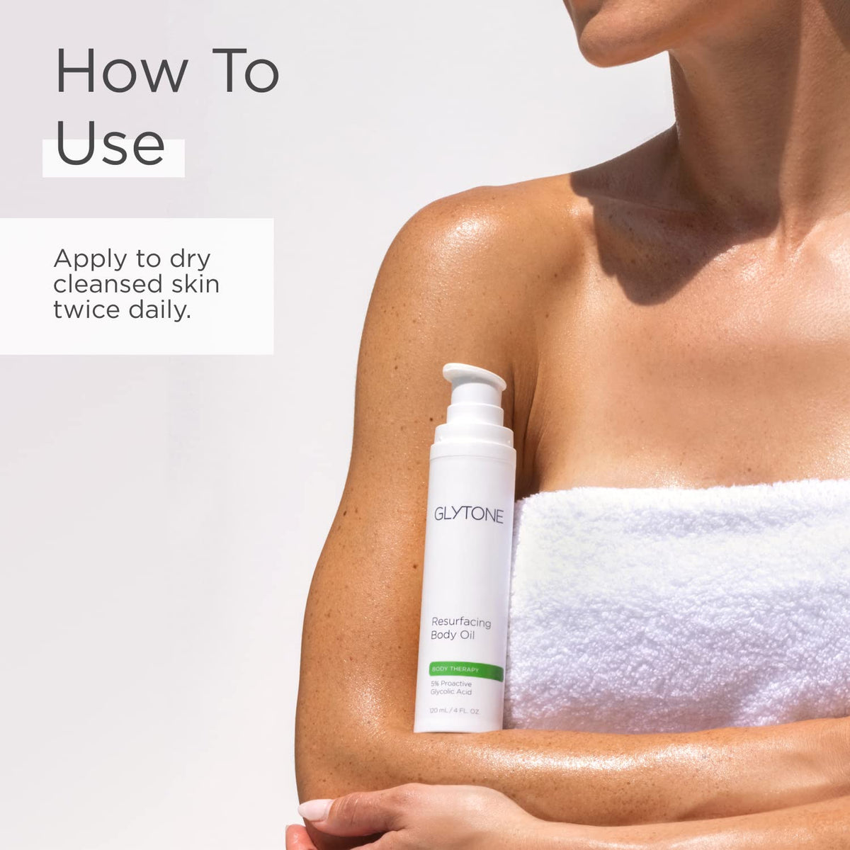 GLYTONE applying oil after shower to arm for smoother, hydrated skin