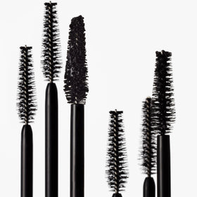 goop Featherlash next to a ruler showing 0.15 fl oz compact travel-friendly size