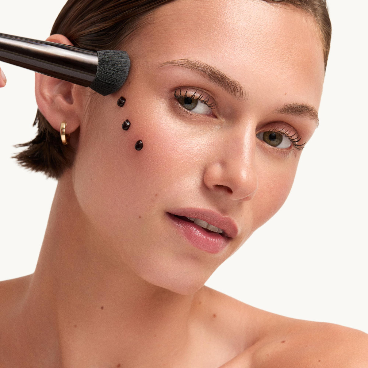 goop Summertone applied on model’s cheek showing instant healthy glow