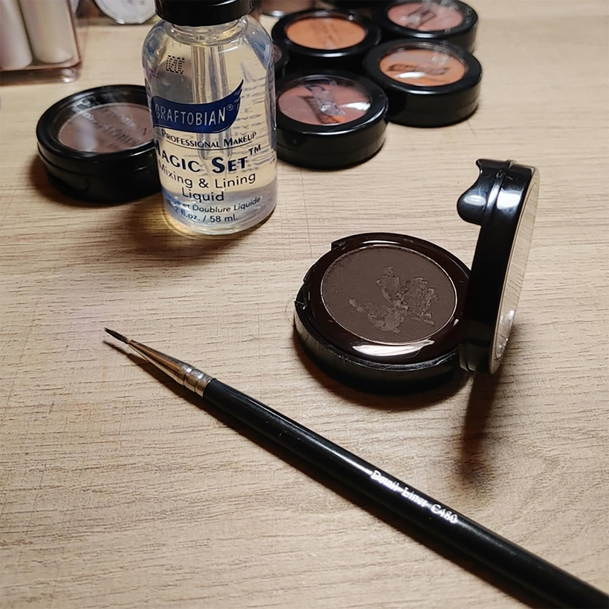 Graftobian compact next to coin indicating portable size and travel convenience