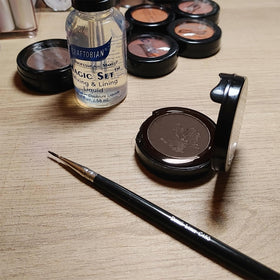 Graftobian compact next to coin indicating portable size and travel convenience