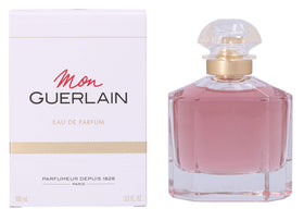 Guerlain Mon Guerlain 3.3 oz beside everyday items showing compact travel-friendly size