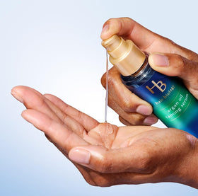 Hair Biology applying serum to damp hair to reduce frizz and improve manageability