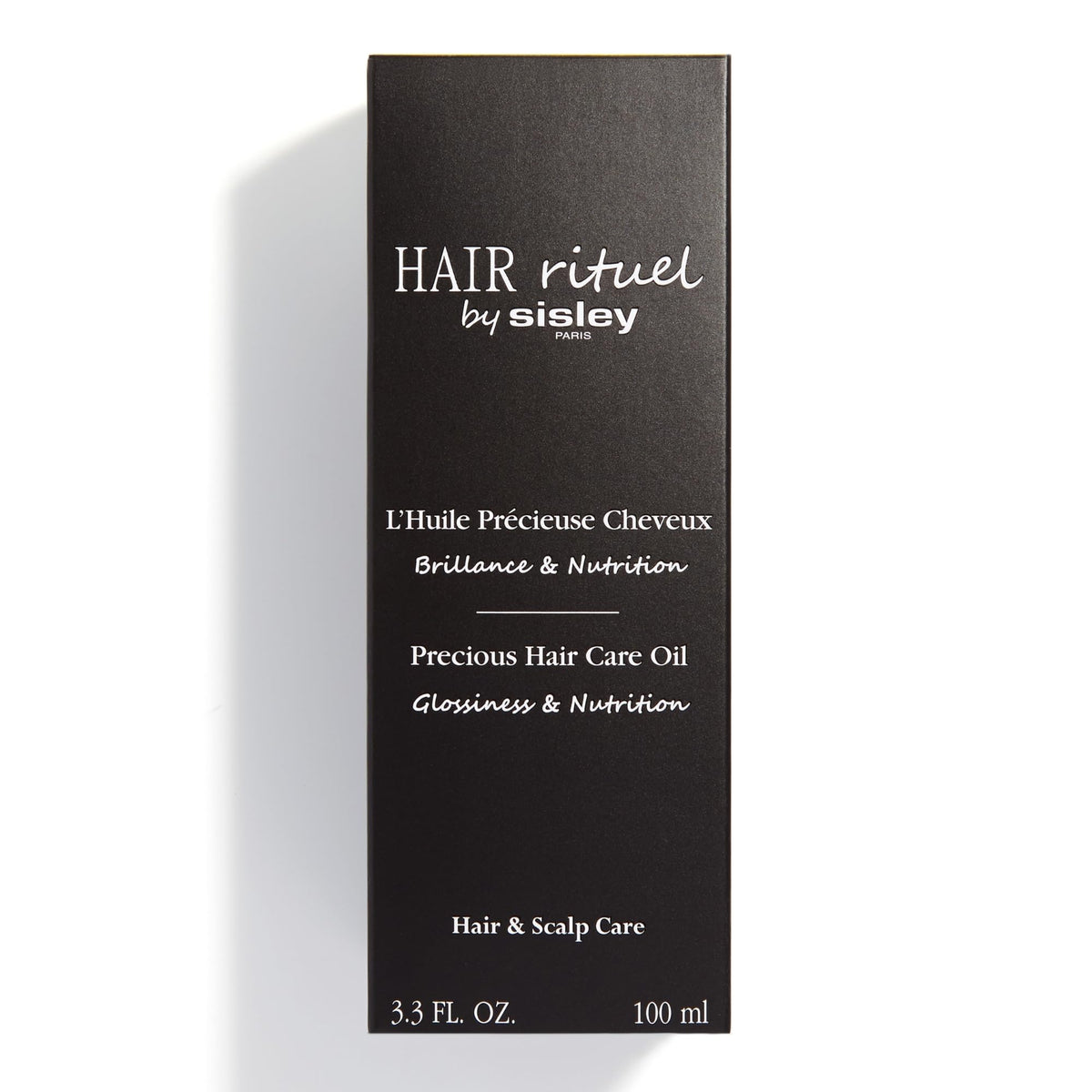 Hair Rituel by Sisley 100 mL bottle next to hand for scale and travel-friendly benefit