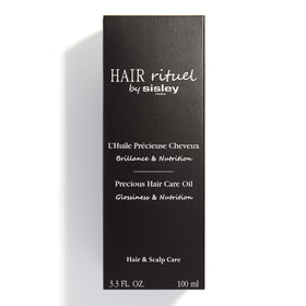 Hair Rituel by Sisley 100 mL bottle next to hand for scale and travel-friendly benefit