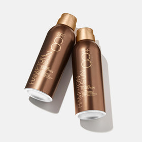 Hampton Sun mist in use sprayed onto arm demonstrating even bronze tint and hydrating finish