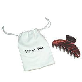 Hana Mia clip tucked in a purse illustrating portability and on-the-go touch-ups